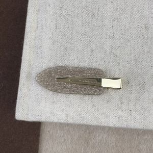 Détail d'une pince à cheveux champagne pailletée avec fermoir en métal doré