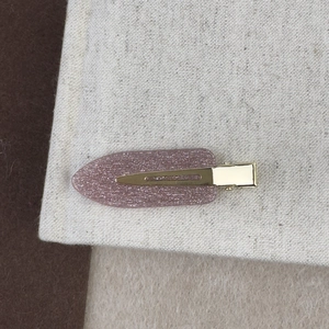 Détail d'une pince à cheveux à paillettes roses avec base en métal doré élégante