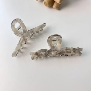 Vue détaillée de deux pinces à cheveux en acétate à motif marbré avec ressorts en métal