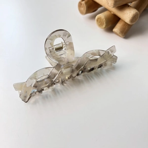 Détail macro d'une pince à cheveux en acétate marbré avec ressort en métal doré