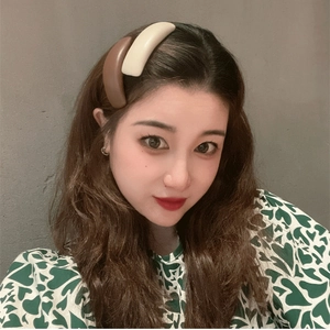 Close-up of matte resin hair clip in beige and brown colors on model's side hair