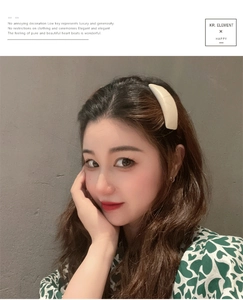 Close-up of minimalist cream-colored leather hair clip worn by model on side hair