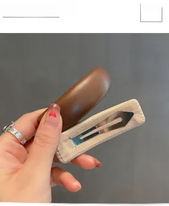 Detail showing the brown leather texture and beige suede lining of the hair clip