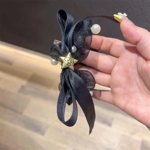 Eleganter schwarzer Haargummi mit Schleife, weißen Perlen und goldener Sternschnalle