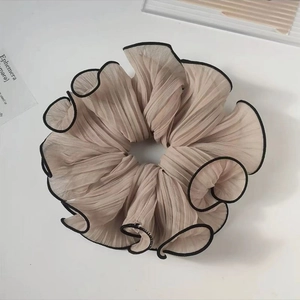 Close-up of jumbo pleated chiffon hair scrunchie with contrast piping and soft texture