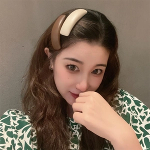 Minimalist beige and brown leather hair clips worn on a woman's side wavy hair