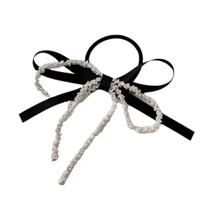 Pinza per capelli a fiocco nero stile francese con perline bianche su fondo bianco