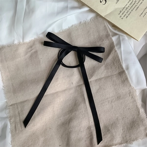 Elegante elastico per capelli in raso nero con fiocco e nastri lunghi su lino