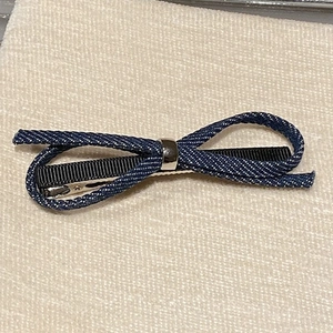 Detailed macro view of the navy blue denim bow hair clip with silver metal ring