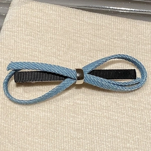 Detailed macro view of the sky blue woven bow hair clip with silver ring and black base