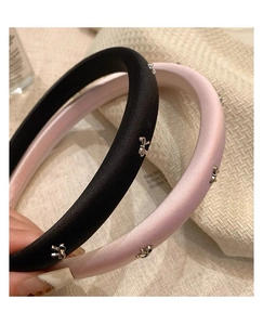 Detail of padded headbands featuring satin fabric and silver bow metal accents