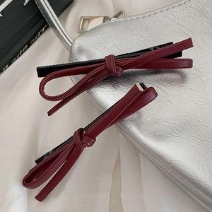 Set of two burgundy faux leather bow hair clips with black metal duckbill hairpins