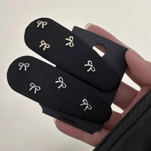 Elegant black fabric BB hair clips with silver metal bow accents on display card