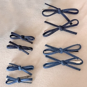 Detailed set of denim blue bow hair clips showing various sizes and fabric textures
