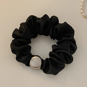 Elegant black satin scrunchie with silver bead detail on minimalist background