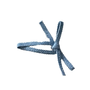 Blue denim fabric bow hair clip with twill weave texture on a clean white background