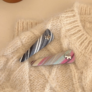 Close-up of fabric hair clips with plaid patterns and silver terrier dog metal accents