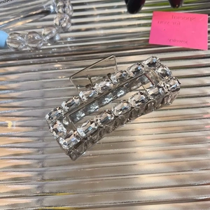Sparkling crystal rectangular hair claw clip with rhinestones on a silver background