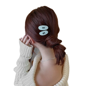 Elegant mint green tweed bow hair clips for women shown on a model hair bun