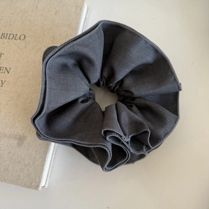Deep grey pleated fabric hair scrunchie in a high-quality cotton linen texture