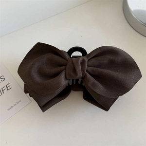 Large dark brown bow hair claw clip with thick fabric texture for elegant hair styling