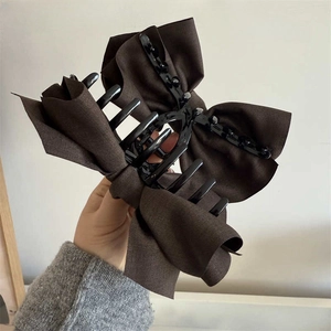 Detailed view of layered dark brown linen-textured oversized bow hair claw clip