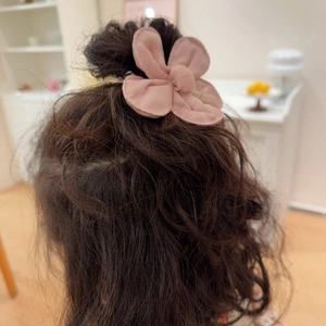 Detail of pink embroidered fabric flower hair clip with delicate petal layers for girls