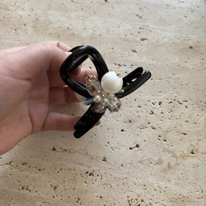 Detail of elegant black shark hair clip featuring white pearls and faceted crystal beads