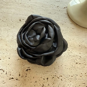 3D black faux leather rose hair claw clip on stone background for elegant styling