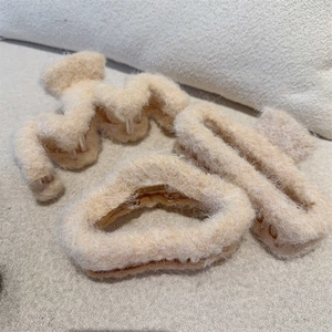 Three plush beige faux fur hair claws in heart, cross and rectangular shapes for women