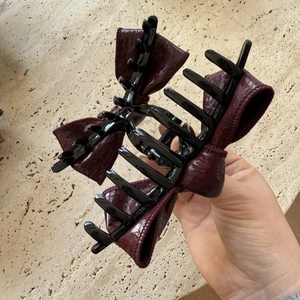 Detailed view of large burgundy faux leather bow hair claw clip with pleated texture