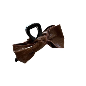 Glossy faux leather bow claw clip in vintage dark brown for elegant hair styling