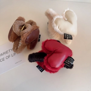 Détail de pinces à cheveux en peluche avec cœur en marron, blanc crème et rouge et noir