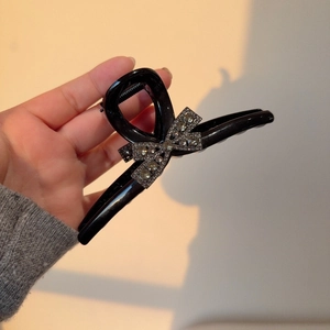 Large black shark hair clip with a sparkling rhinestone bow for elegant hair styling