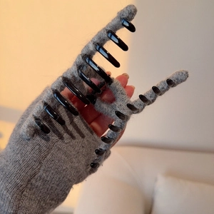 Large grey knit hair claw clip for thick hair shown in hand for autumn winter style