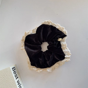 Elegant black velvet hair scrunchie with lace trim and a gold charm in French retro style