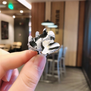 Detailed macro shot of a mini acetate hair claw clip with black and white marble pattern