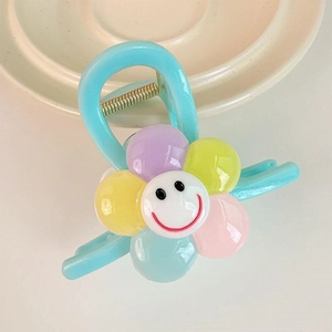 Pince à cheveux fleur bleue avec pétales colorés et motif de visage souriant pour fille