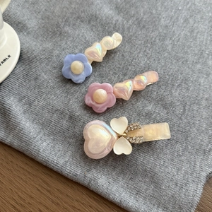 Dettaglio dei fermagli per capelli in acrilico colorato con strass e perle