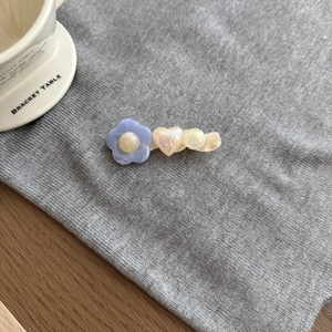 Dettaglio del fermaglio per capelli a fiori color pastello con cuore in acrilico