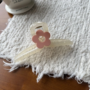 Detailopname van een elegante crème-witte haarklem met een roze bloem voor vrouwen