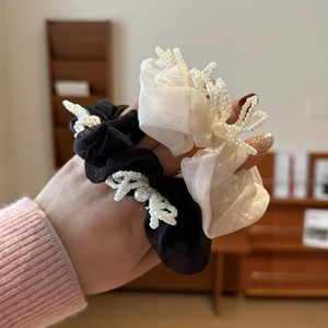Detail of elegant black and white tulle scrunchies with white pearls and 3D bow decor