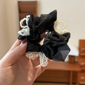Close-up of black mesh scrunchie with handmade pearl flower accents for hair styling