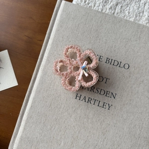 Close-up of pink flower hair claw clip with pearl texture and crystal heart bow