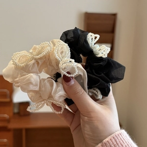 French tulle scrunchies with pearl bows in black and champagne shown on wrist