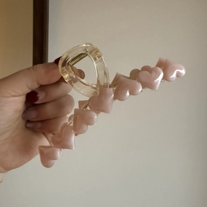 Dettaglio della molletta per capelli con cuori rosa in resina trasparente e molla robusta
