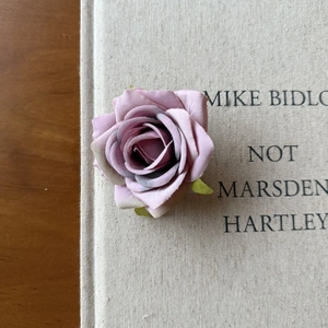 Detail of elegant dusty pink velvet fabric rose hair clip with realistic petal textures