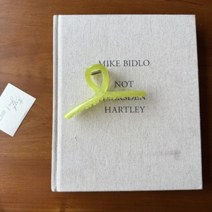 Gros plan sur une pince à cheveux en acrylique vert translucide sur un livre élégant