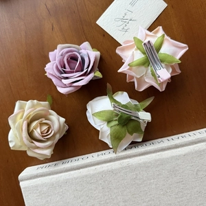 Set of four velvet rose flower hair clips in purple pink beige and white on wood