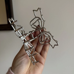 Détail de la pince à cheveux papillon en alliage argenté avec design ajouré chic